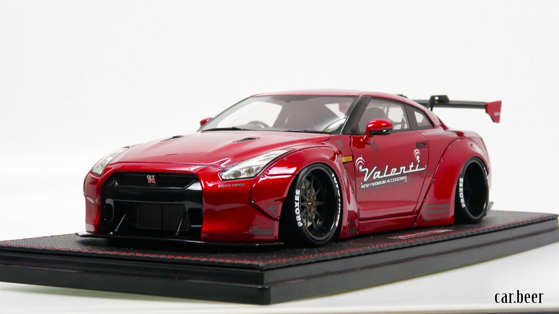 紅色日產GT-R模型車，帶Valenti品牌標誌，置於展示支架上。