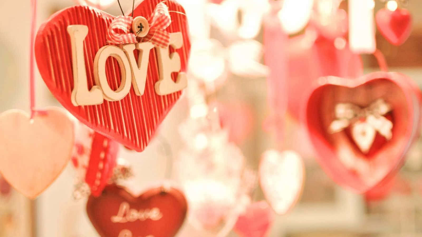 可愛情人節gif 桌布 壁紙 — 紅色木心心形掛飾，帶有「LOVE」字母，在溫暖浪漫的展示中柔和地亮起。