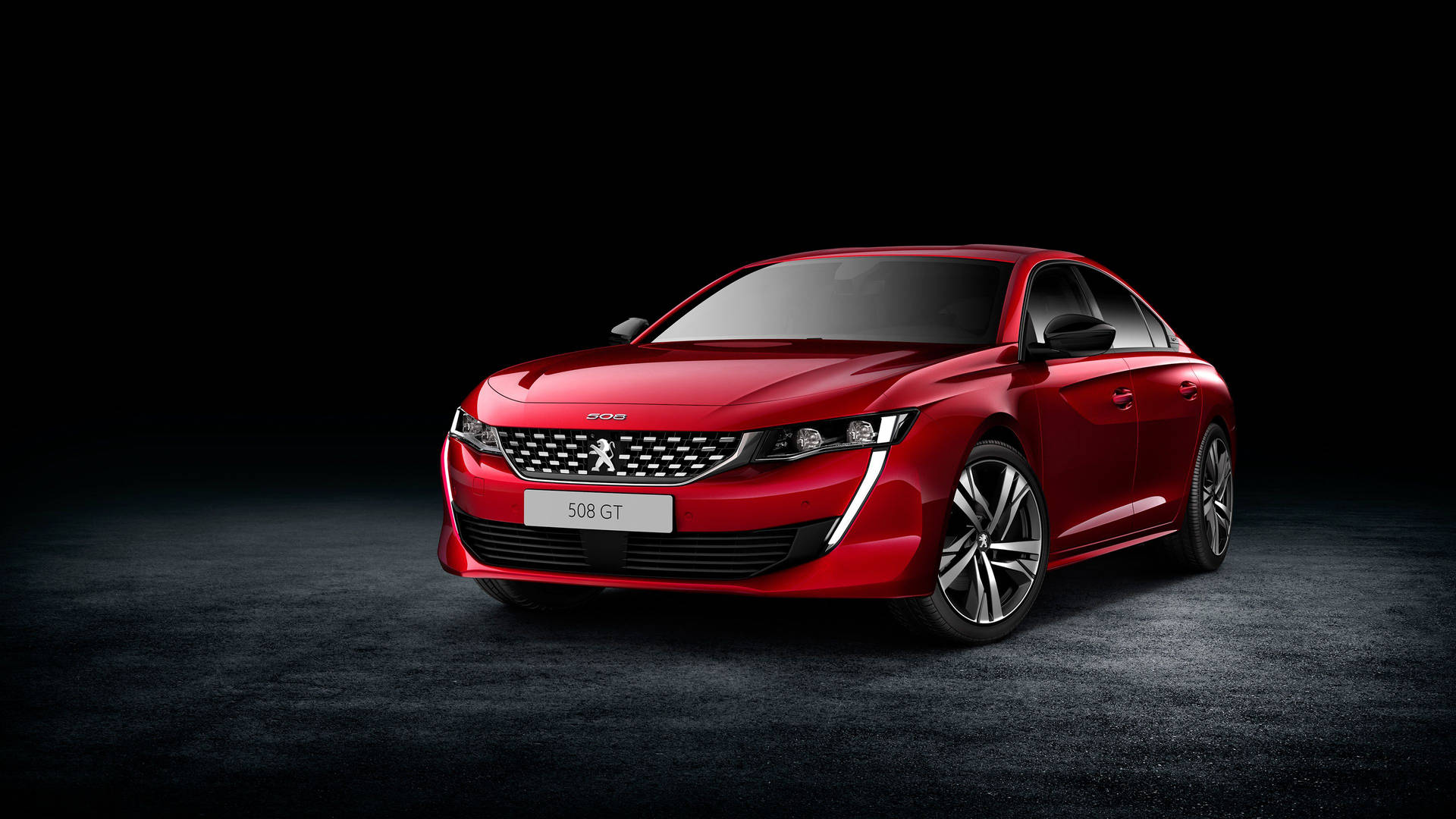 紅色Peugeot 508 GT轎車在攝影棚中，帶有戲劇性燈光和深色地板。