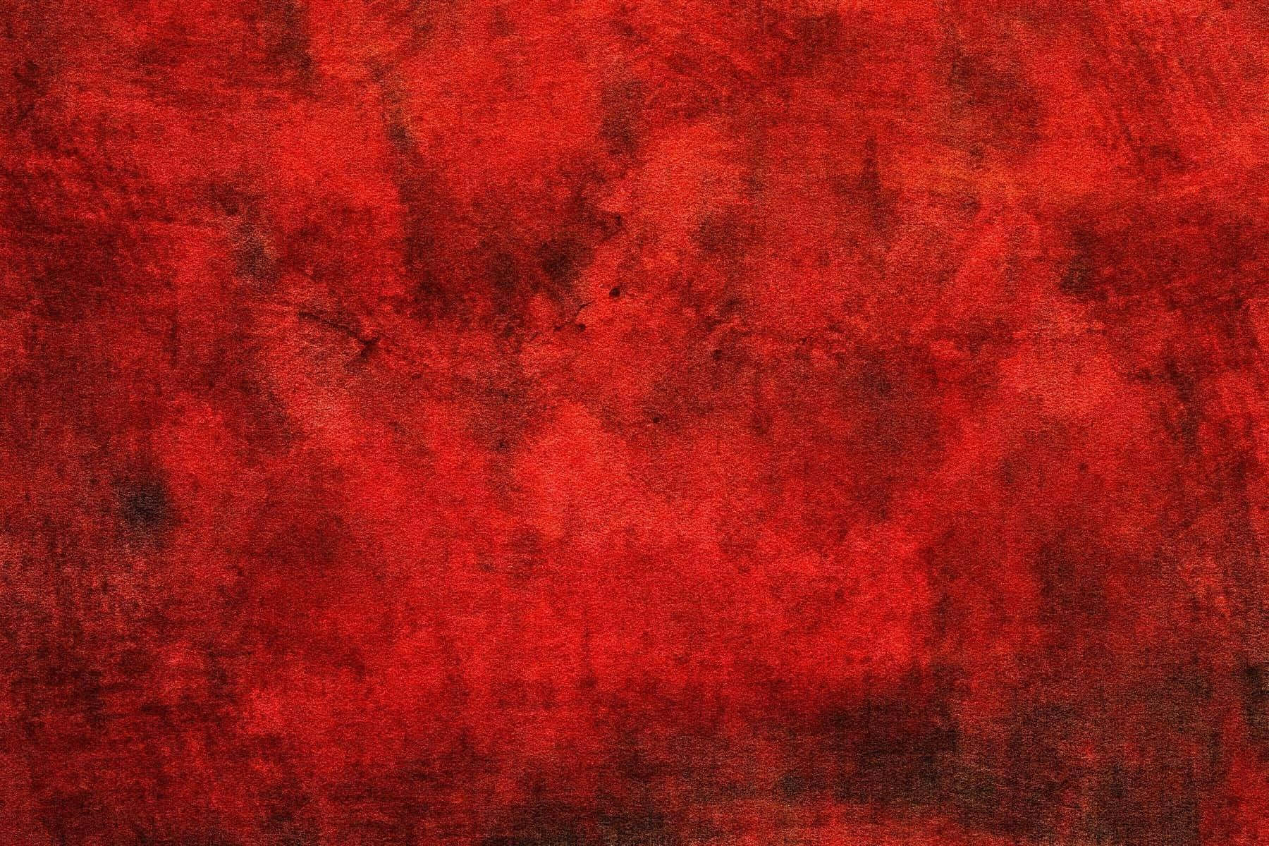 紅色紋理抽象畫圖 壁紙 — 一個質感豐富的紅色表面，帶有深色污跡和不均勻的筆觸圖案，形成大膽的抽象畫布。