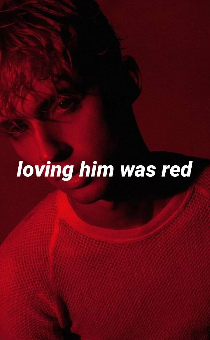 年輕男子在紅光下的特寫肖像，帶有文字 loving him was red。