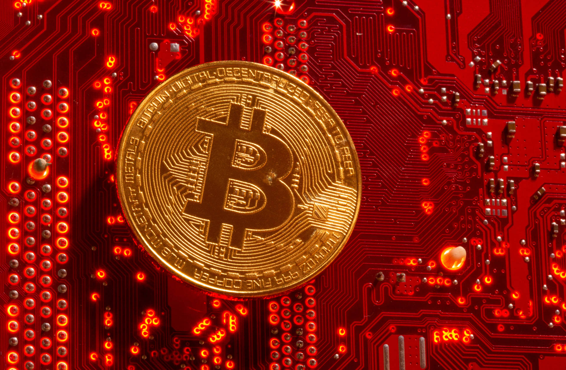 發光紅色電路板上的金色比特幣硬幣