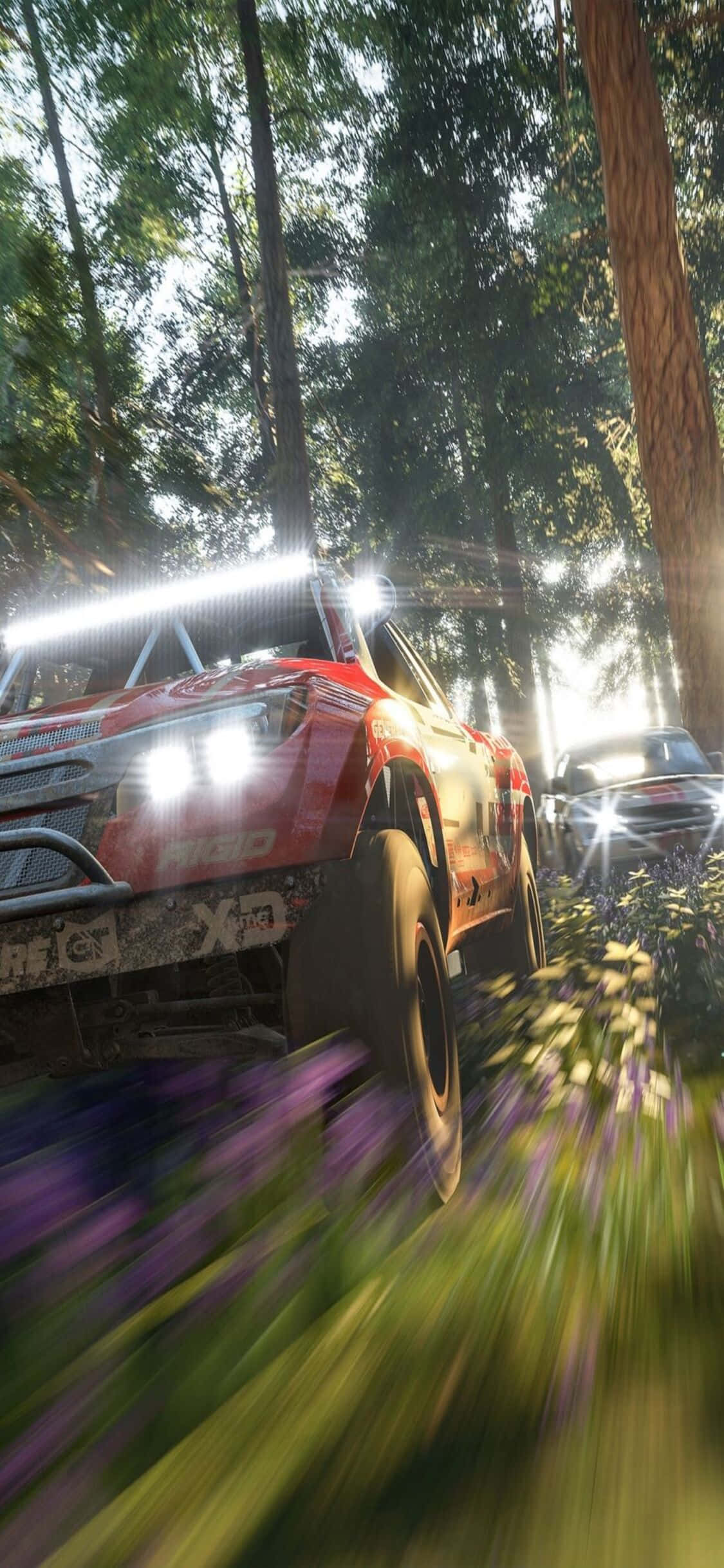 紅色越野車 iPhone X《Forza Motorsport 7》背景 壁紙 — 一輛紅色拉力賽車在陽光明媚的森林中疾馳，紫色的花朵因運動而模糊。