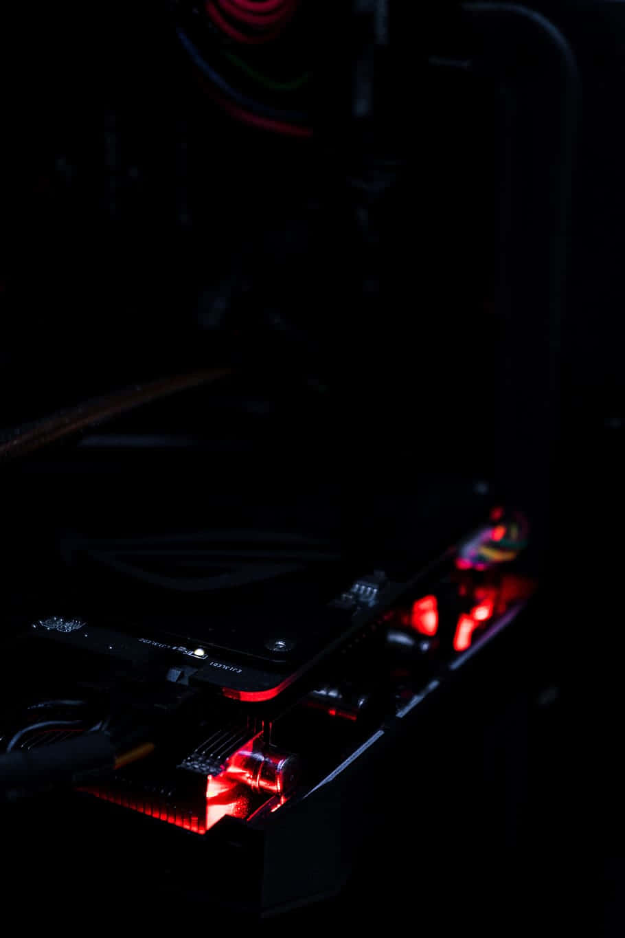 紅色遊戲設置硬碟圖片 壁紙 — 暗房內電腦主機板發出紅色LED燈光的特寫。