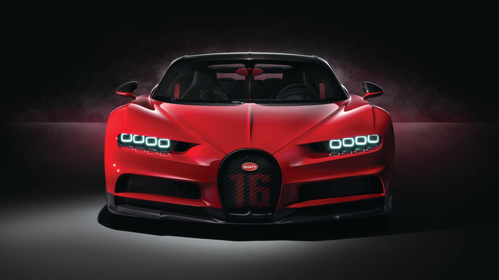 紅色Bugatti Chiron Super Sport 16在黑暗的攝影棚中帶有發光的頭燈。
