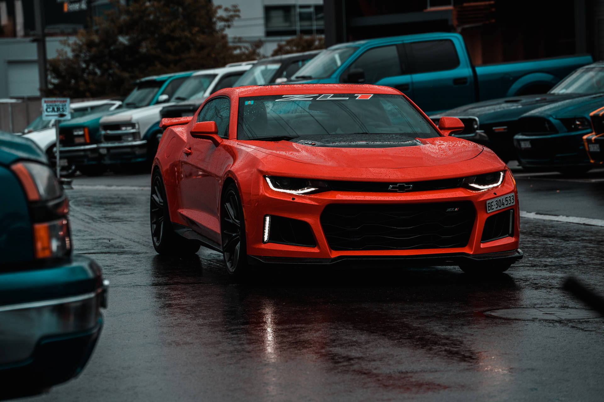 紅色雪佛蘭Camaro ZL1停放在城市停車場的潮濕瀝青上。