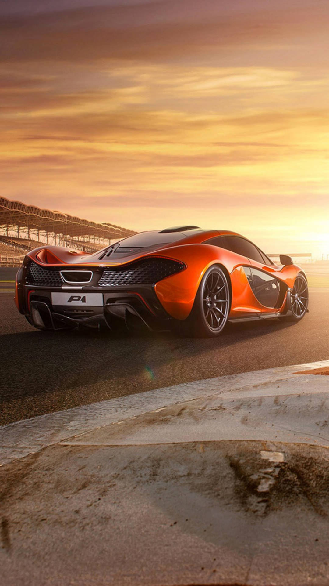 橙色McLaren P1超級跑車在賽道上，金色日落