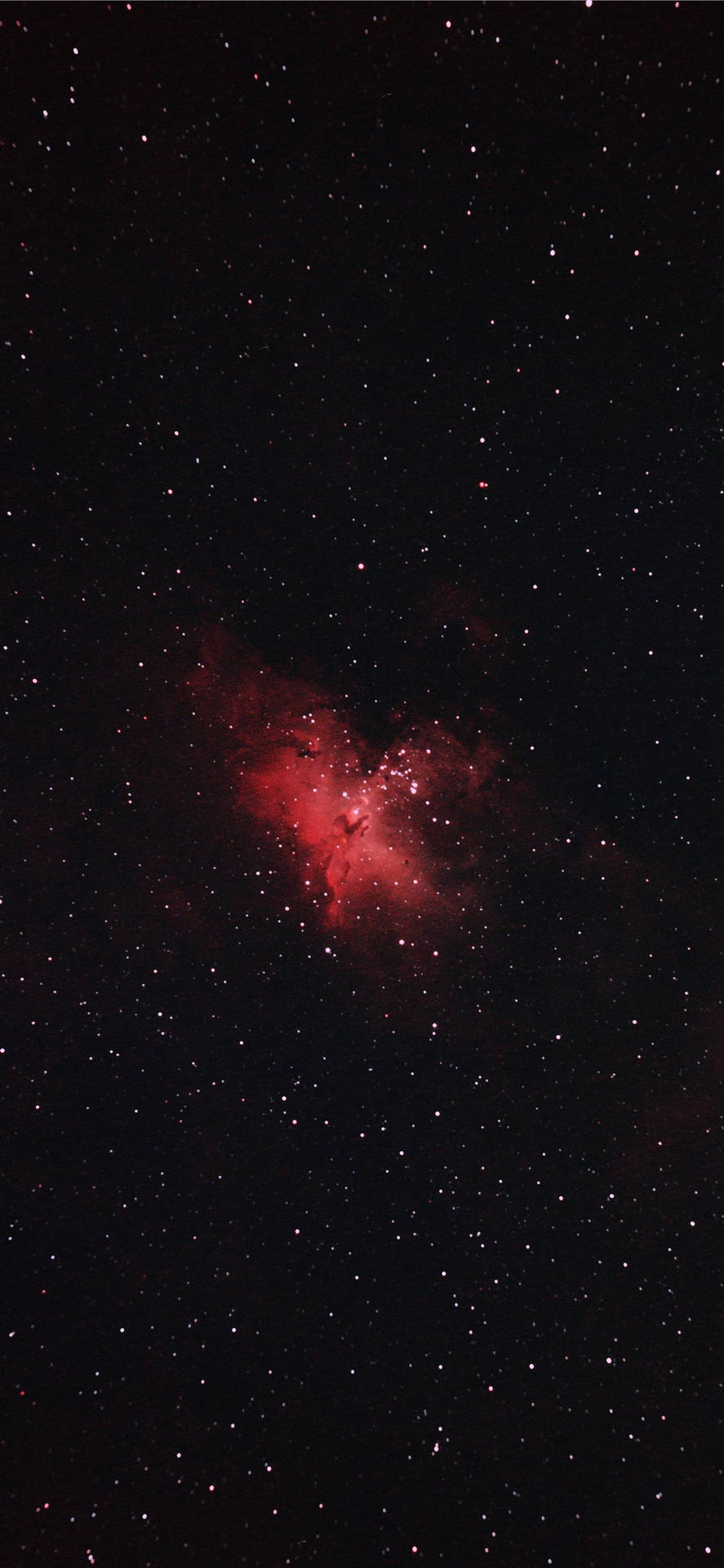 夜空中無數星星環繞的發光紅色星雲。