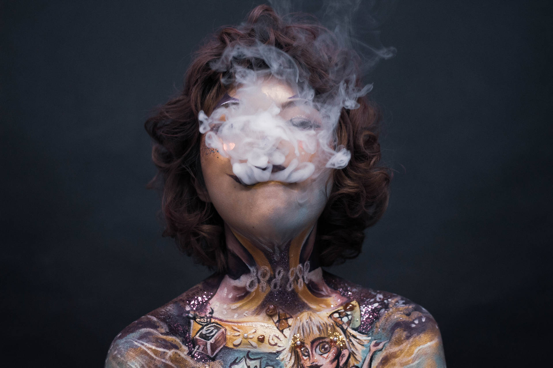 身體彩繪的人在黑暗背景下呼出煙霧