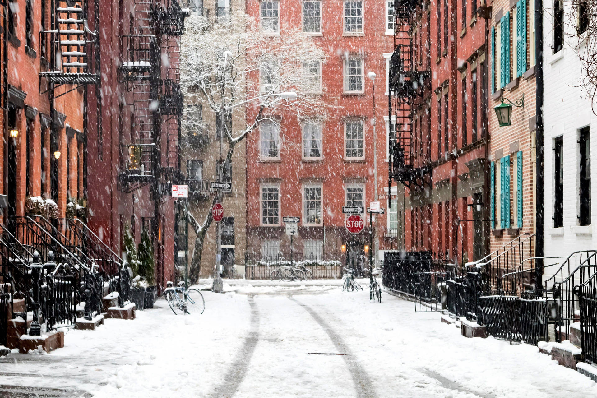 白雪覆蓋的城市街道，有紅磚建築和沿人行道停放的自行車。