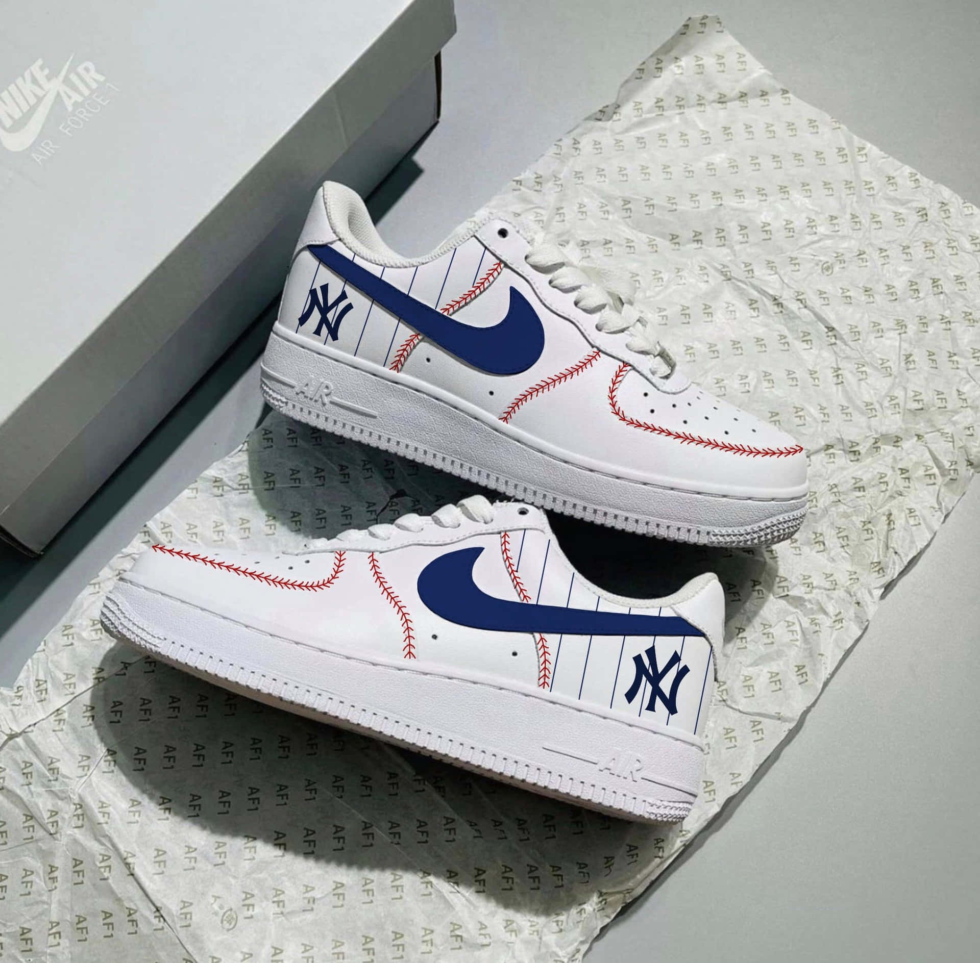 白色Nike Air Force 1運動鞋，帶有棒球縫線和NY標誌，放在品牌紙巾上。