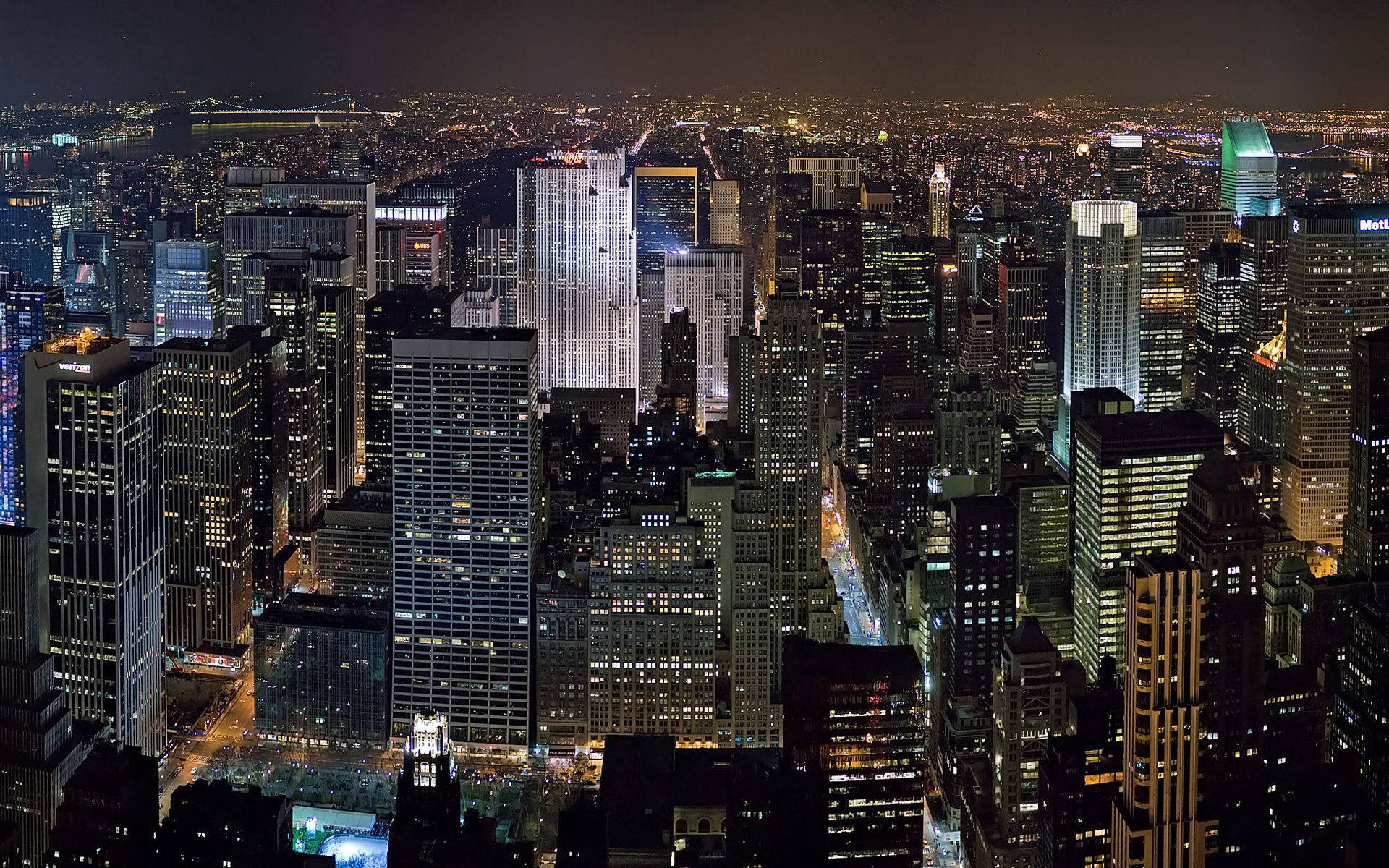 紐約夜景令人屏息 壁紙 — 密集城市天際線的空中夜景，高聳的摩天大樓在黑暗的天空中閃爍著人造燈光。