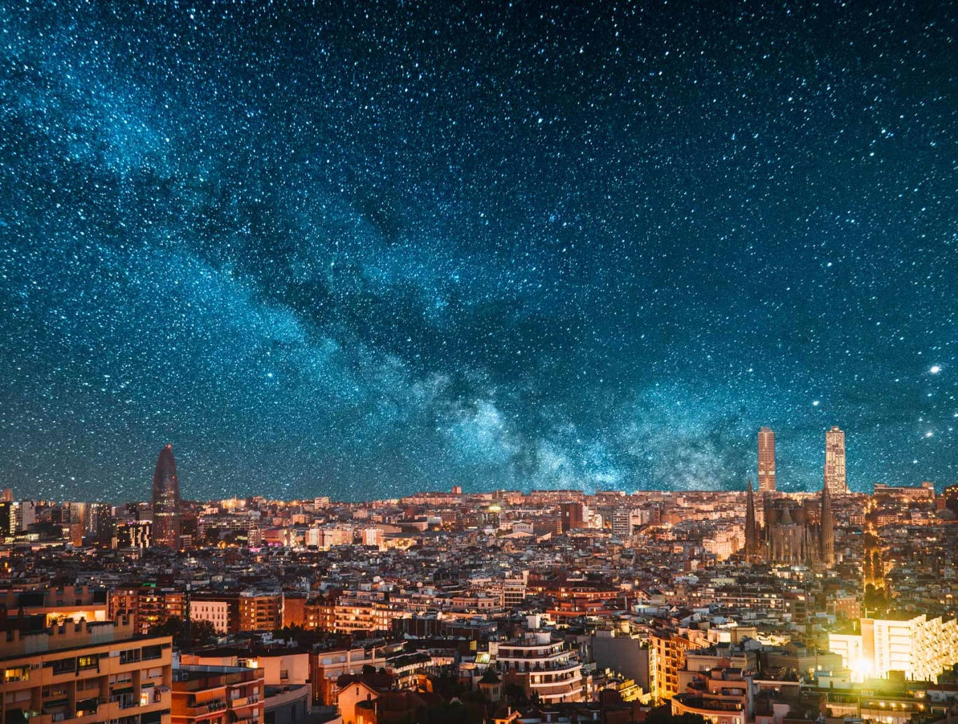 紐約夜景與銀河 壁紙 — 在銀河拱起的 vibrant 星空下，一片廣闊的城市景觀。