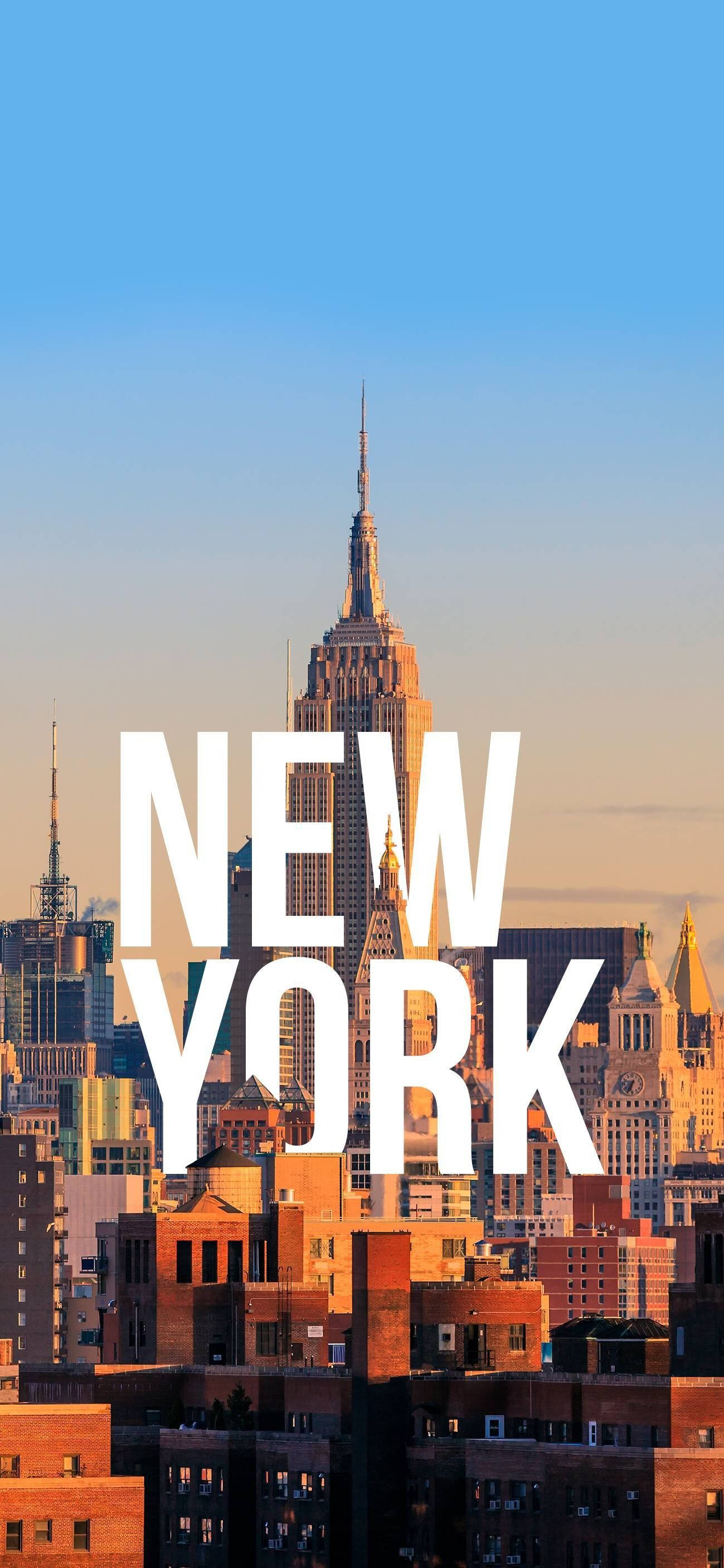 紐約市 iPhone X 字樣標誌 壁紙 — 帝國大廈聳立在陽光明媚的紐約天際線上，並帶有粗體白色文字疊加。