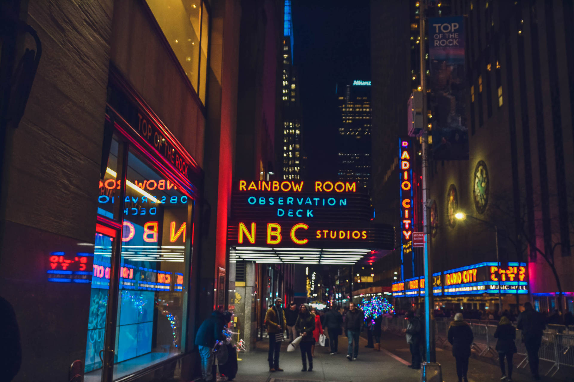 夜晚的城市街道，發光的霓虹燈和行人靠近NBC和無線電城大樓。
