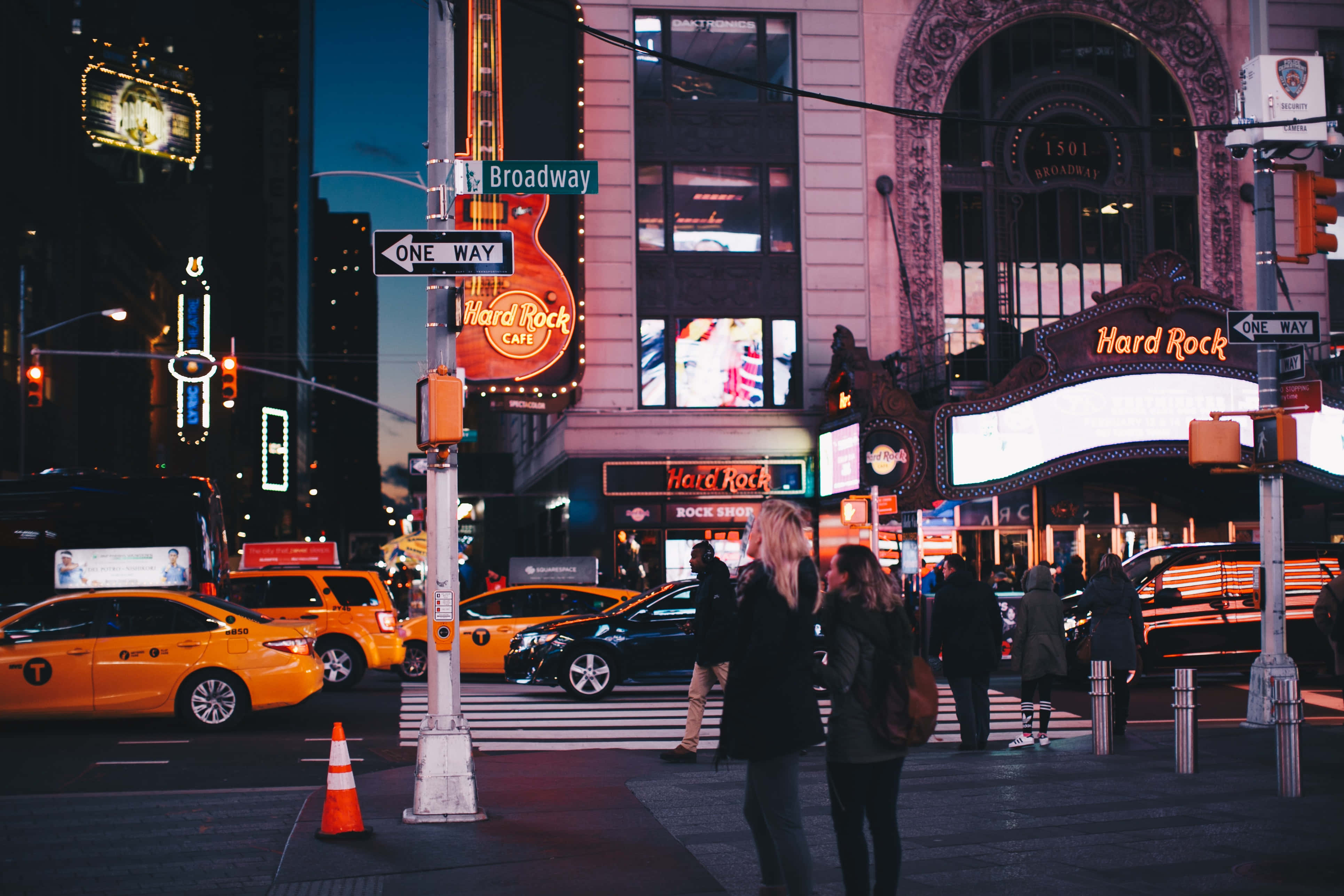 Nyc 桌布 壁紙 — 紐約市充滿活力的夜間街景，帶有發光的Hard Rock Cafe標誌和黃色的士。