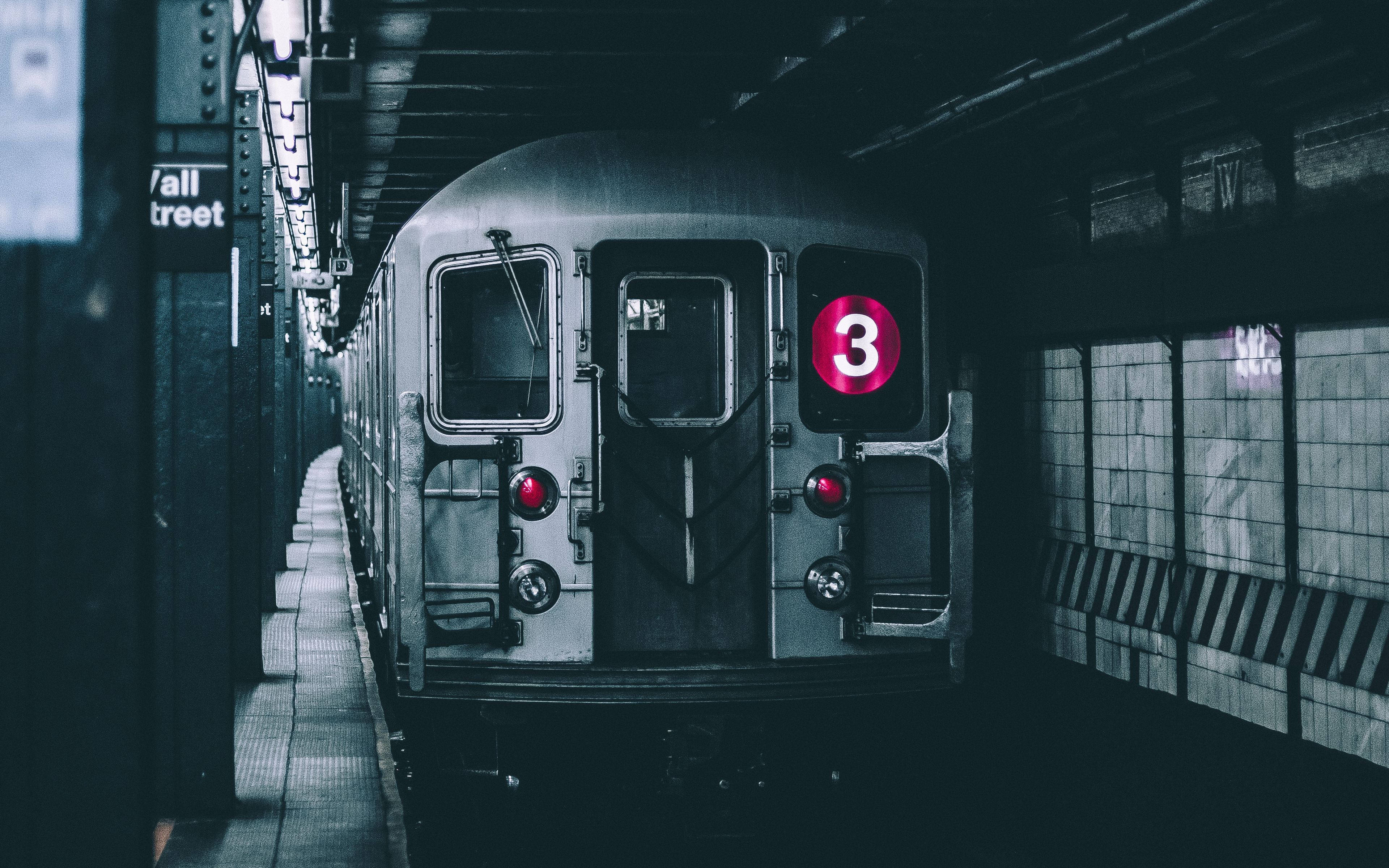 紐約市地下地鐵列車 壁紙 — 一列復古地鐵列車帶有發光的粉紅色三號標誌，停靠在燈光昏暗的地下車站月台上。