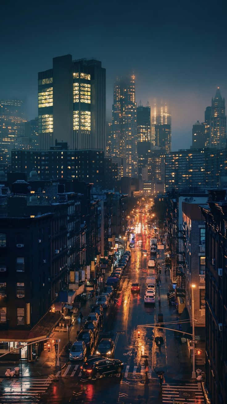 夜晚潮濕的街道，發光的燈光反射在人行道和背景的高樓上。