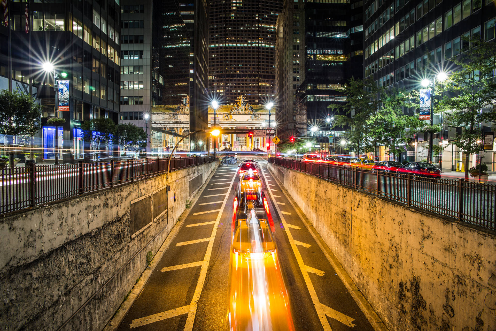 夜間城市隧道，帶有飛馳的車燈光軌和高樓大廈。
