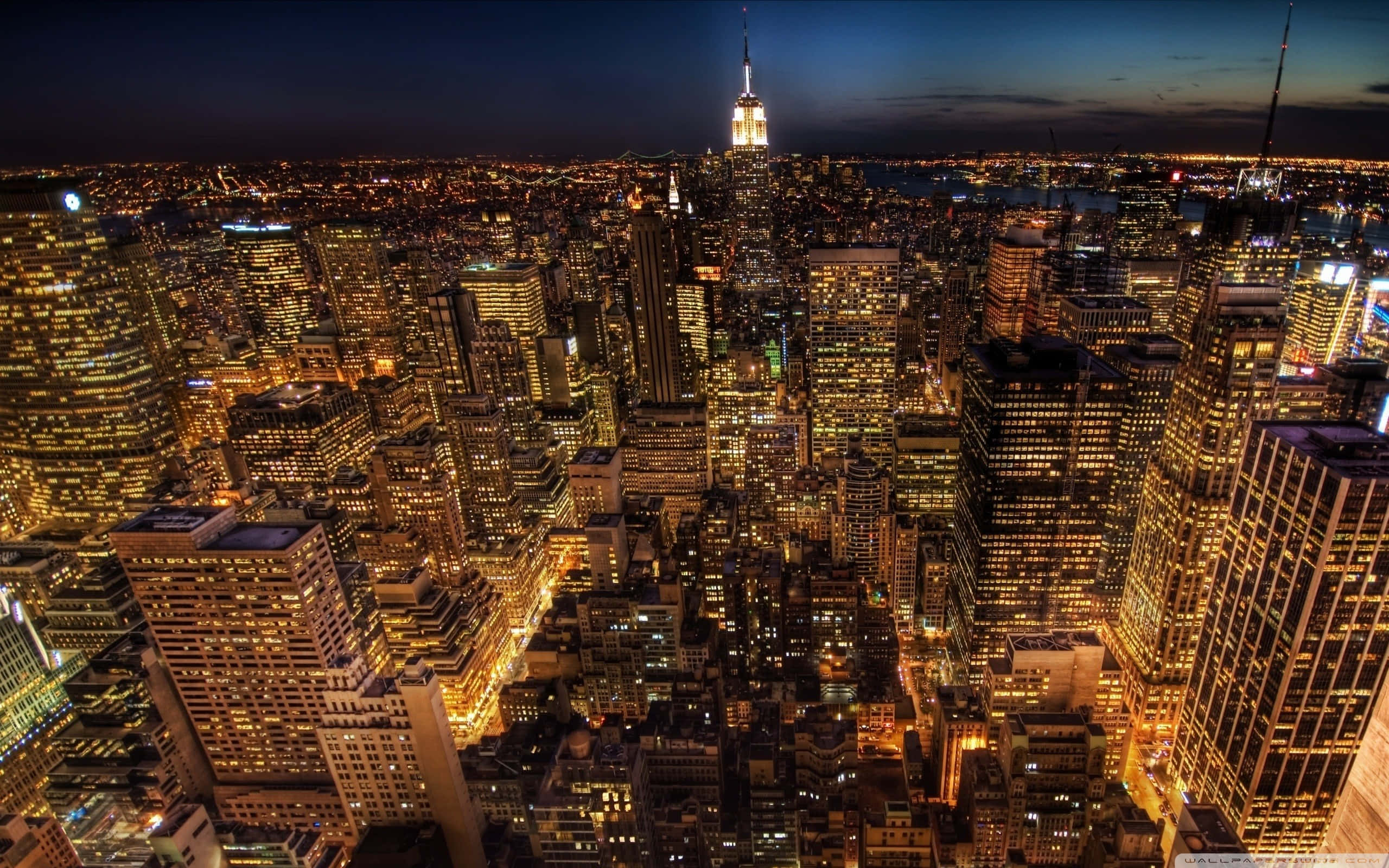 City Lights 桌布 壁紙 — 紐約市夜景鳥瞰圖，摩天大樓閃爍，帝國大廈在黑暗天空下被照亮。
