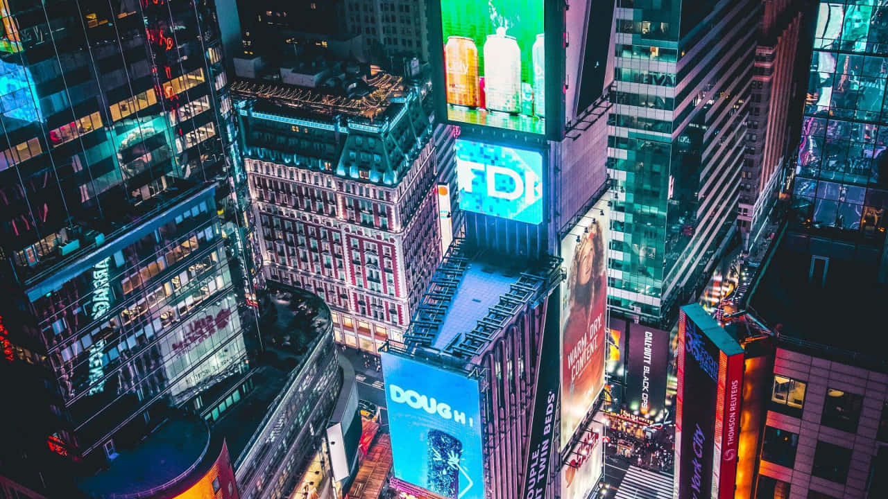 紐約市夜間天際線的壯麗風景 壁紙 — 夜晚時代廣場的鳥瞰圖，高聳的建築物閃爍著充滿活力的數碼廣告牌和霓虹燈。
