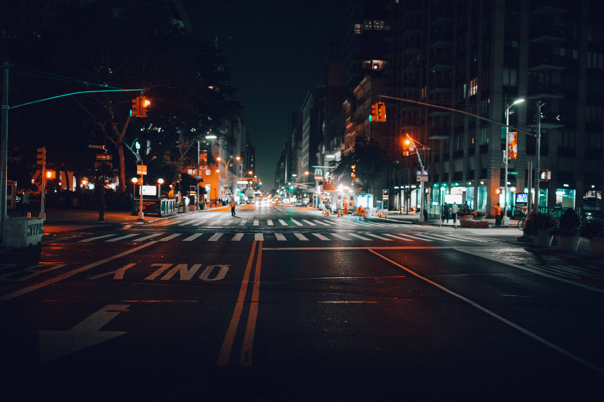 夜晚城市街道，濕漉漉的路面反射交通燈和遠處車輛。