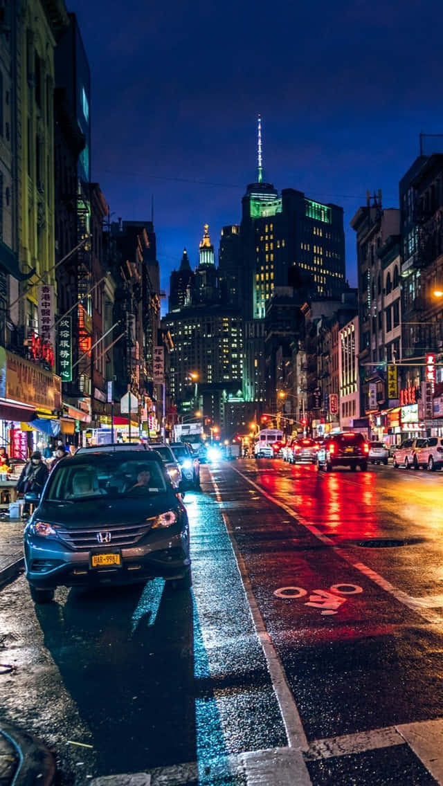 夜晚城市街道，濕漉漉的路面反射霓虹燈光和交通。