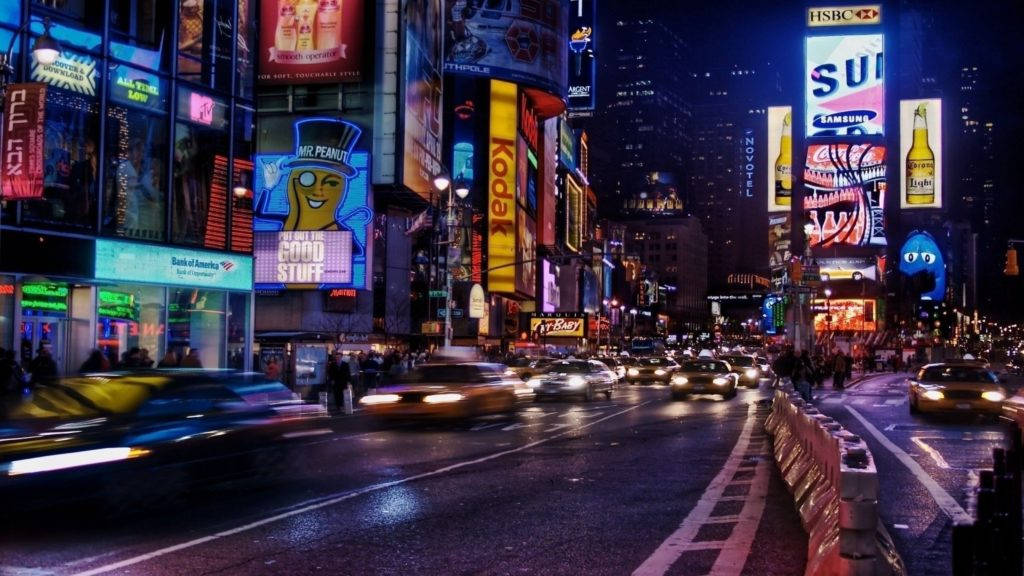 夜晚的時代廣場，明亮的霓虹燈和行駛的汽車。
