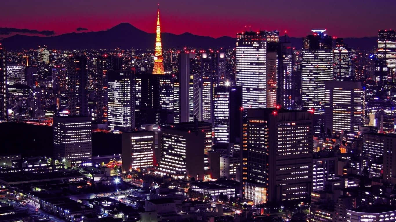 黃昏時分的東京城市燈光，背景是富士山。