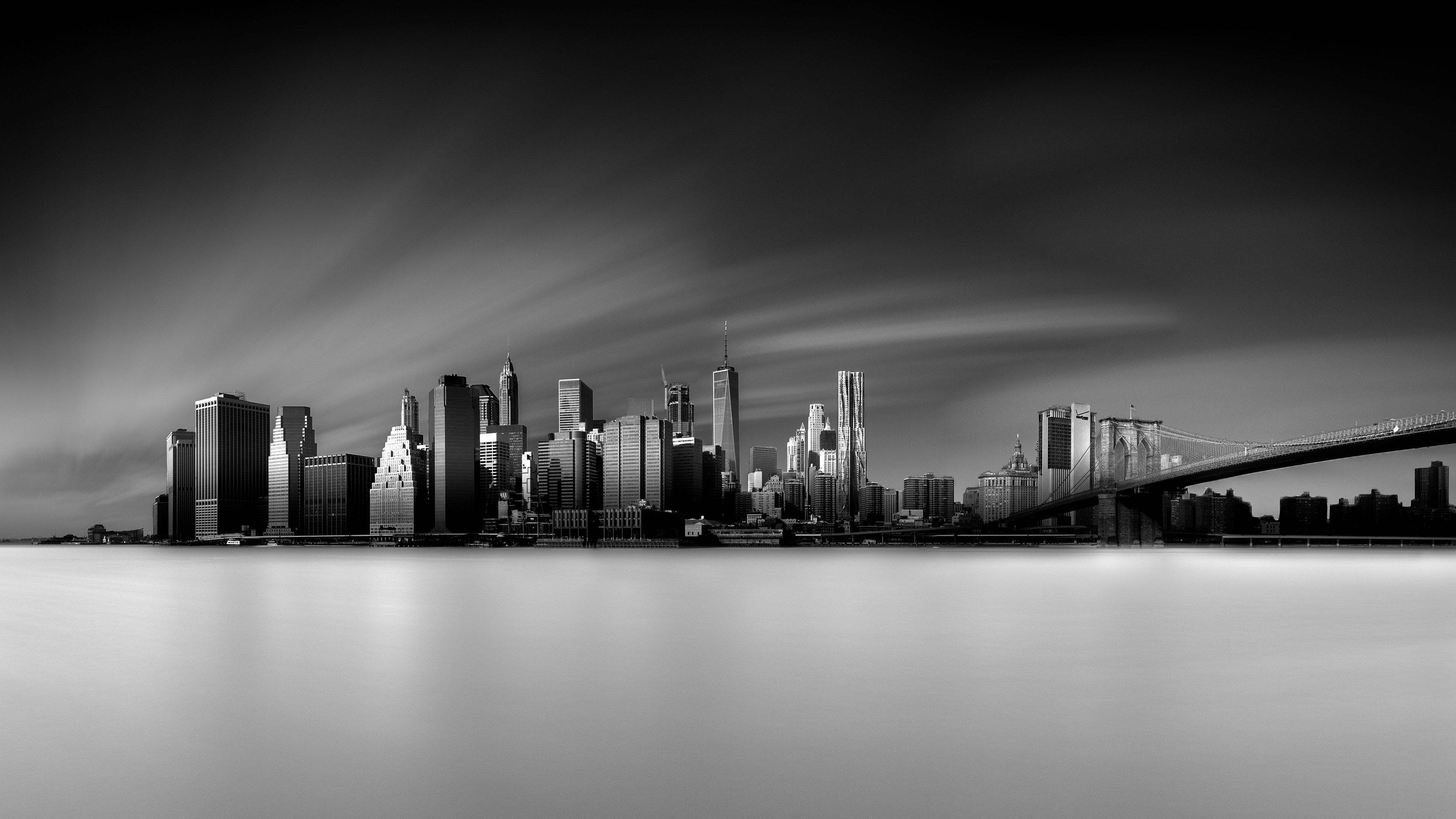 New York 桌布 壁紙 — 紐約市的單色天際線，布魯克林大橋和動態模糊的水面，在戲劇性的雲層下。