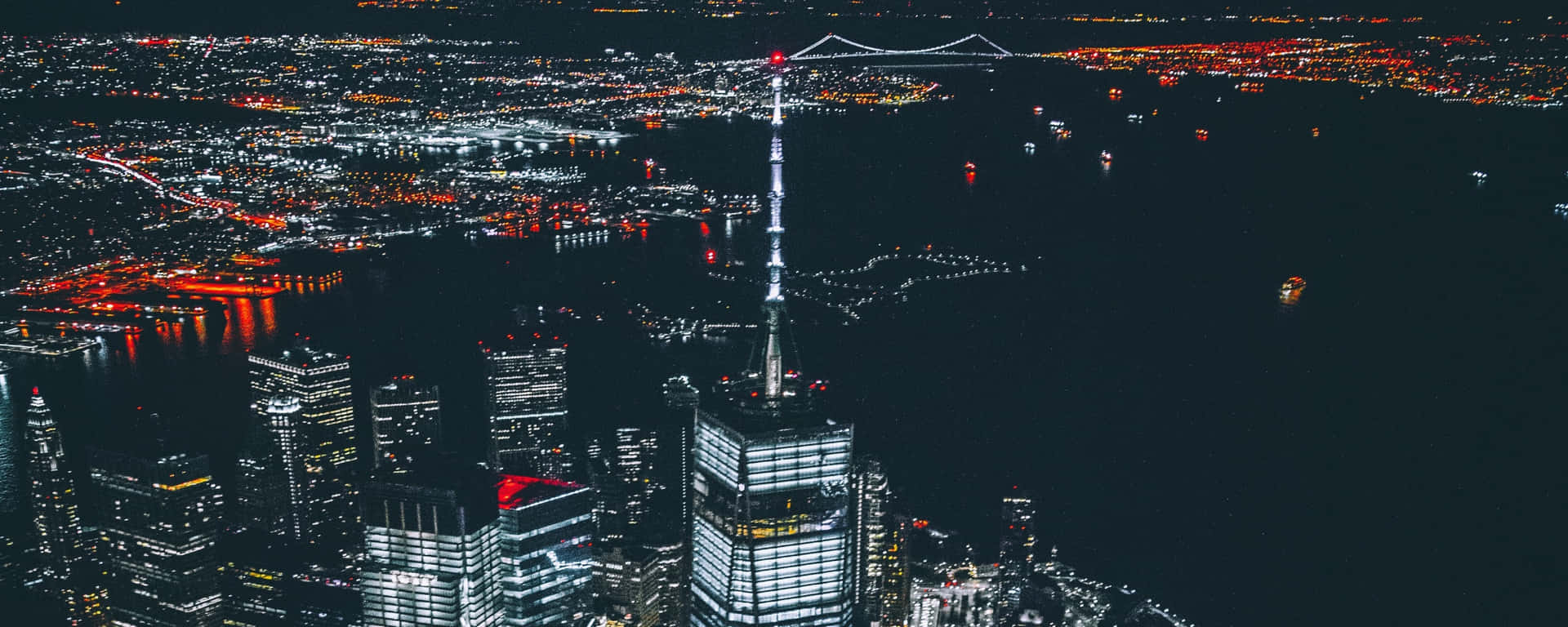 夜晚的東京城市景觀，發光的摩天大樓和水上的橋樑。