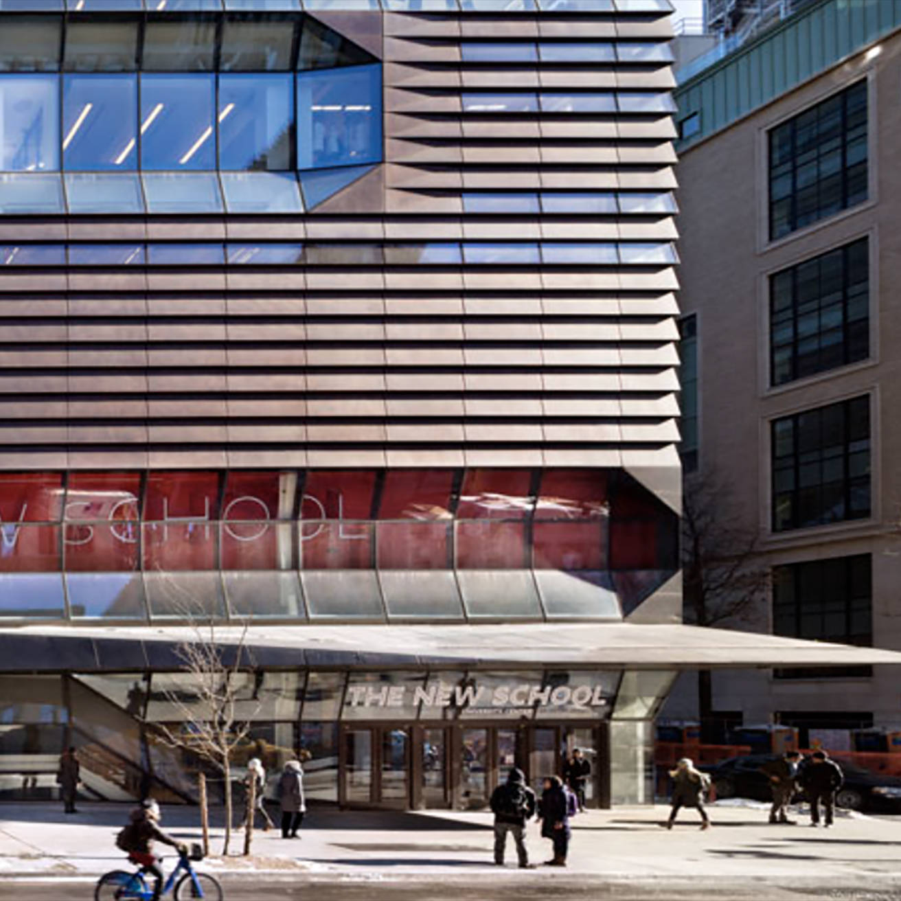 紐約新學校第五大道街角 壁紙 — 現代玻璃和金屬建築，帶有「THE NEW SCHOOL」標誌，人們在明亮的日光下在積雪的人行道上行走和騎自行車。