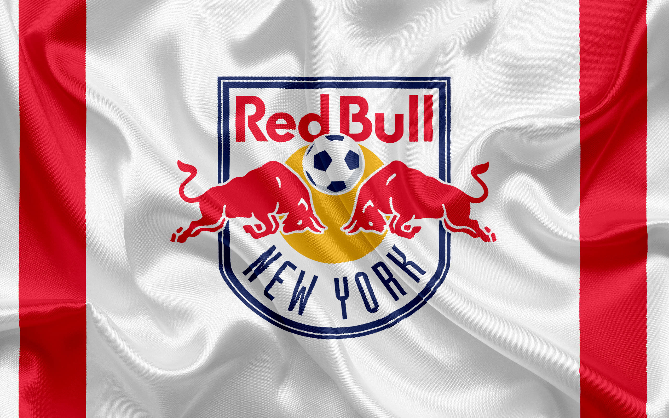 紐約紅牛隊標誌紅白配色 壁紙 — 一面飄揚的紅白旗幟，上面有 Red Bull New York 足球隊的標誌，包含兩頭衝鋒的公牛和一個足球。