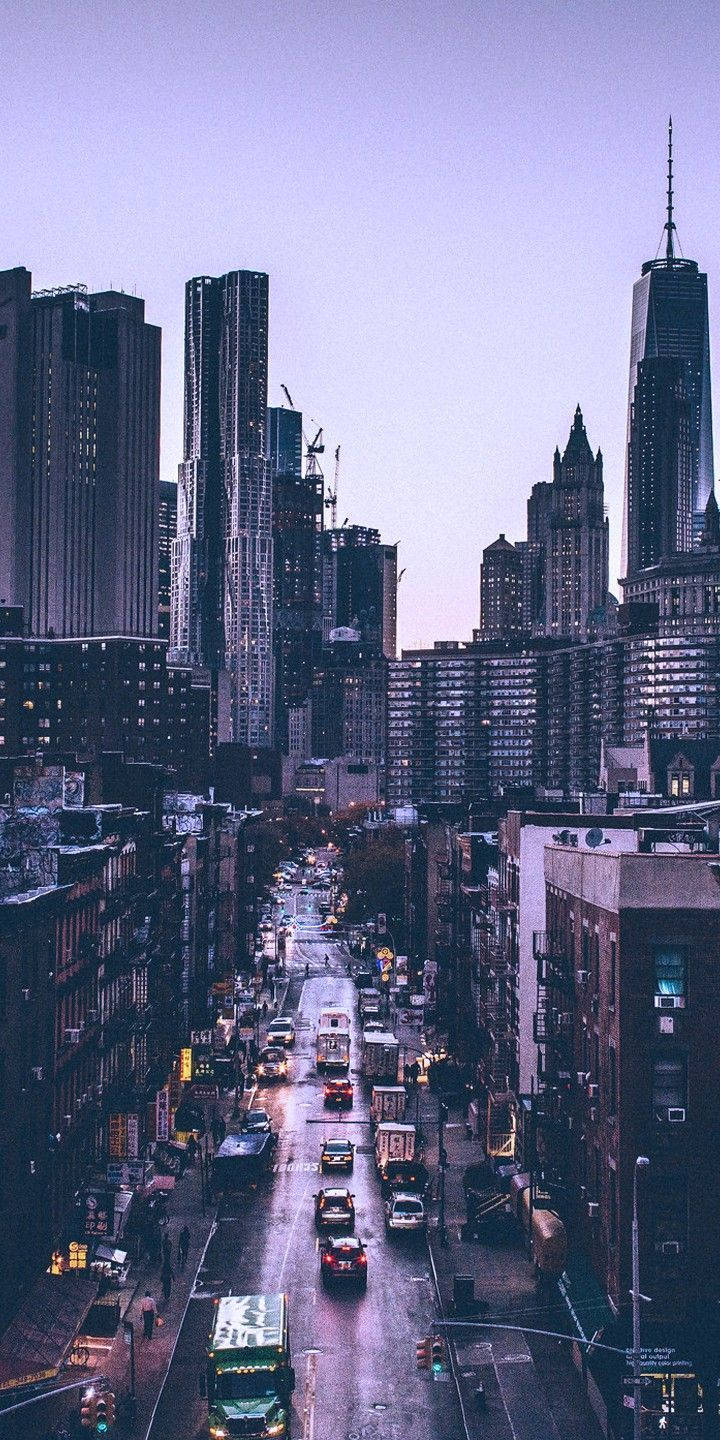 黃昏城市街道，高樓大廈和行駛中的汽車，紫色天空
