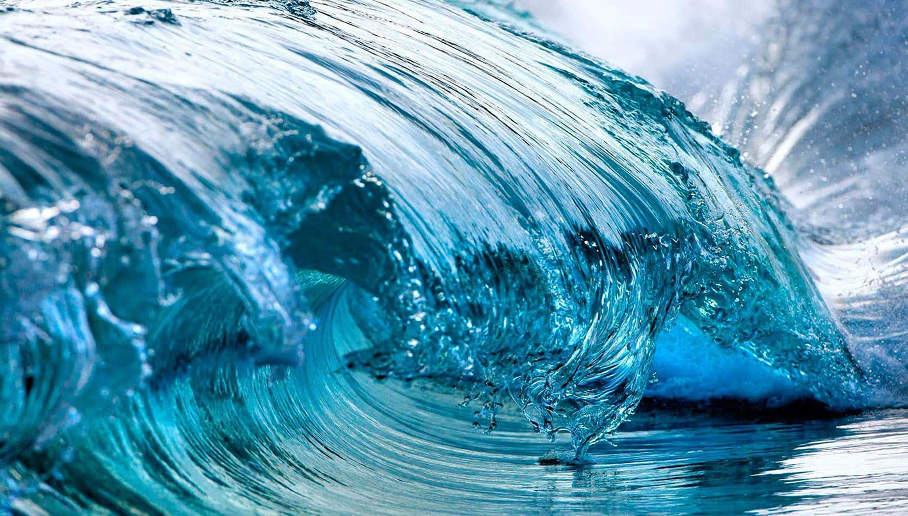 純淨碧綠海洋的壯麗景觀 壁紙 — 一道強勁的藍綠色海浪捲成玻璃狀的隧道，閃爍的水滴凝固在半空中。