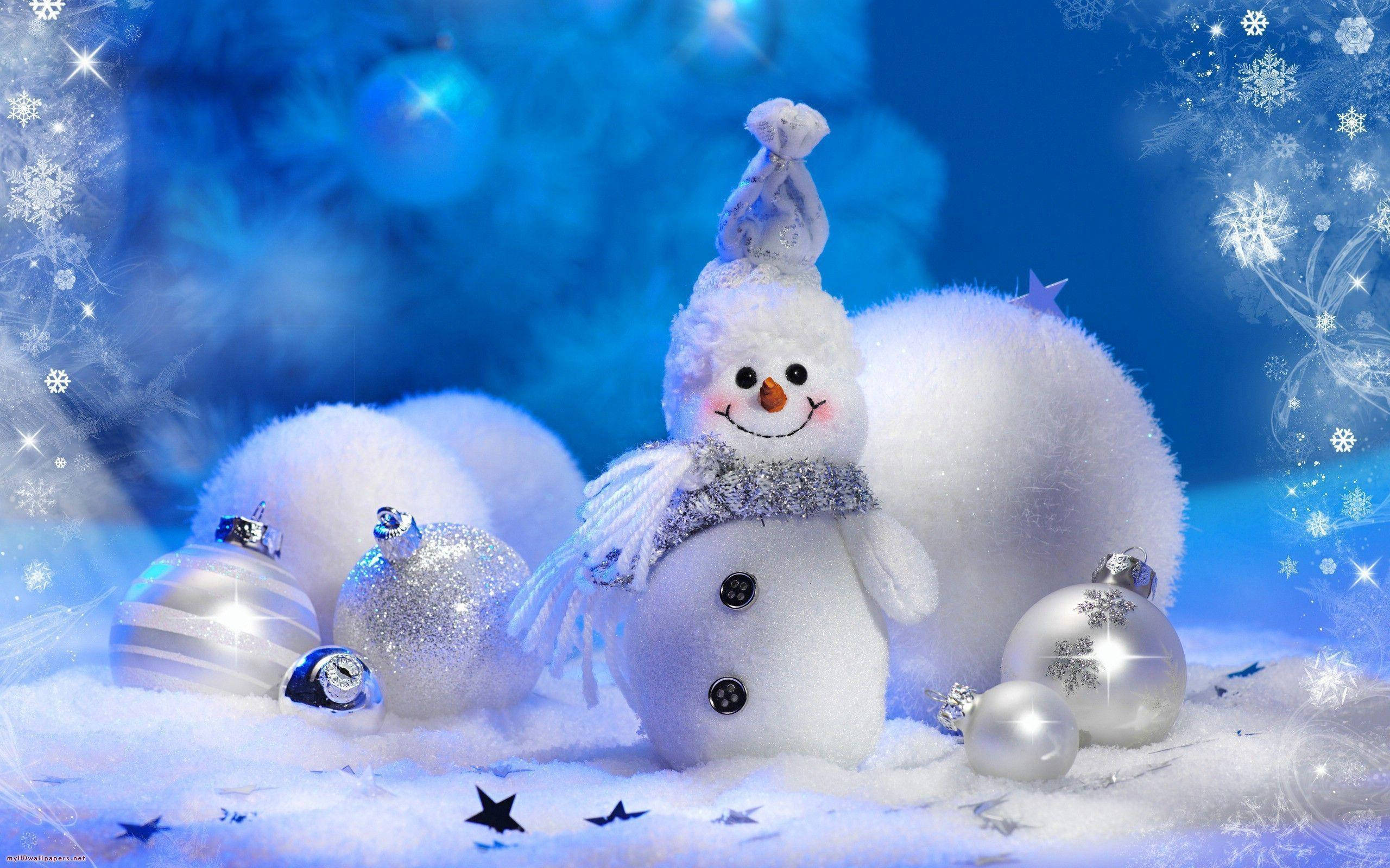 純白聖誕雪人 壁紙 — 一個戴著閃亮圍巾和帽子的快樂雪人，站在被銀色裝飾品和閃閃發光的雪花包圍的雪藍色冬季場景中。