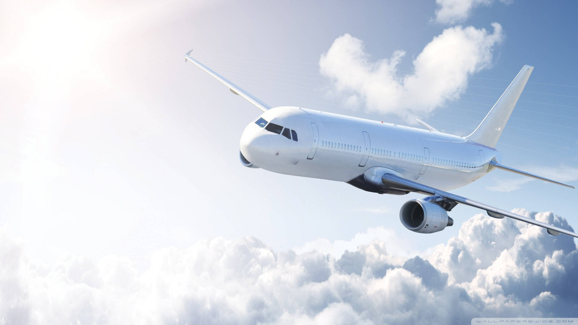 純白飛機 壁紙 — 一架流線型白色客機在明亮的藍天下翱翔於蓬鬆的白雲之上，陽光從左側照射。