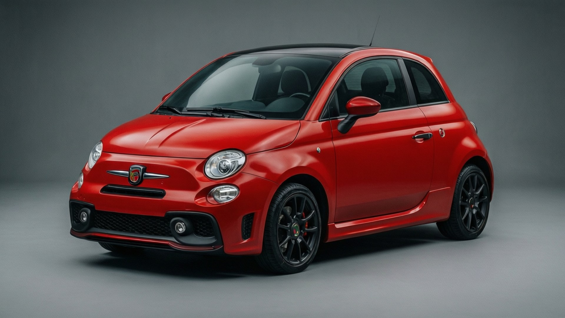 工作室環境中帶有黑色輪圈的紅色Fiat 500汽車