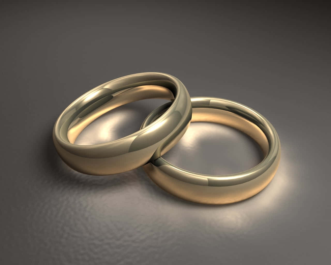 兩枚金質結婚戒指在灰色有紋理表面上交織。