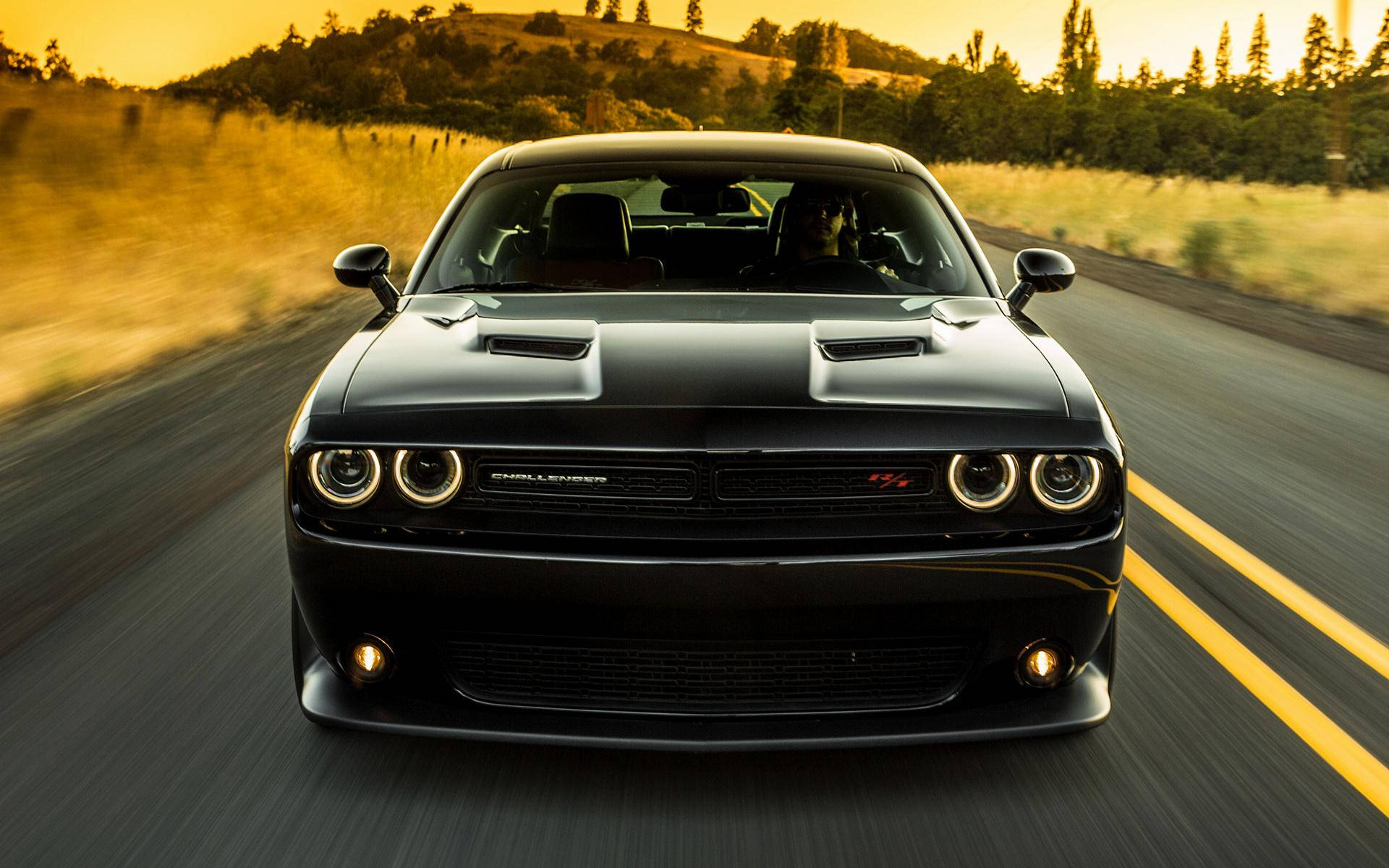 黑色道奇挑戰者在金色日落時分在風景優美的道路上疾馳。 — Dodge challenger GIF 壁紙