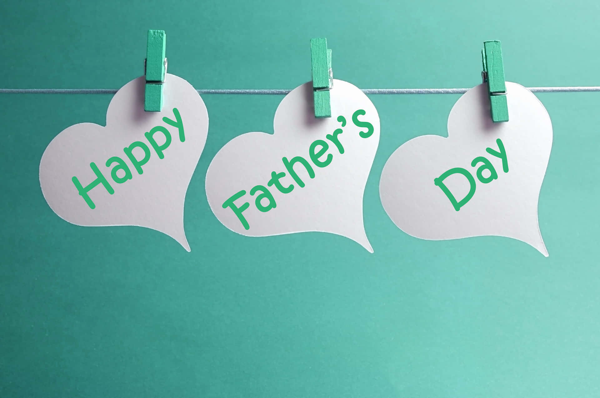 三個心形紙牌寫著「Happy Father's Day」夾在線上。
