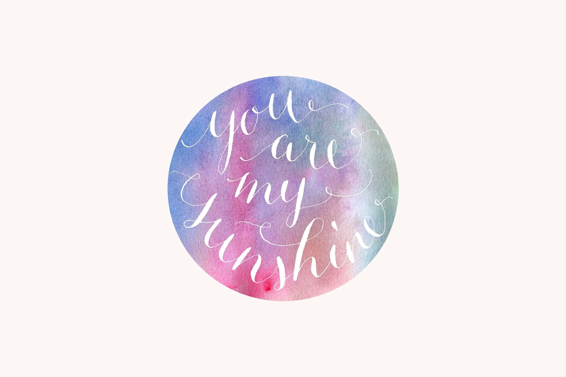 圓形水彩藝術品，帶有草書文字，寫著 you are my sunshine。