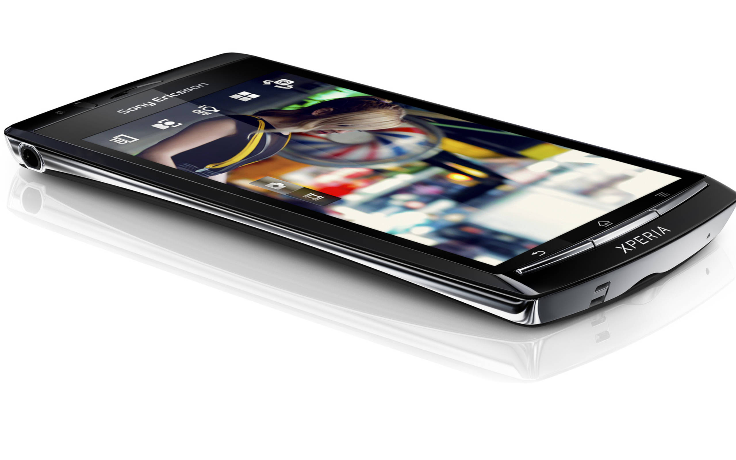 索尼手機白底背景 壁紙 — 一部時尚的黑色Sony Xperia智能手機傾斜放在反光的白色表面上，生動的屏幕顯示色彩繽紛的抽象壁紙。