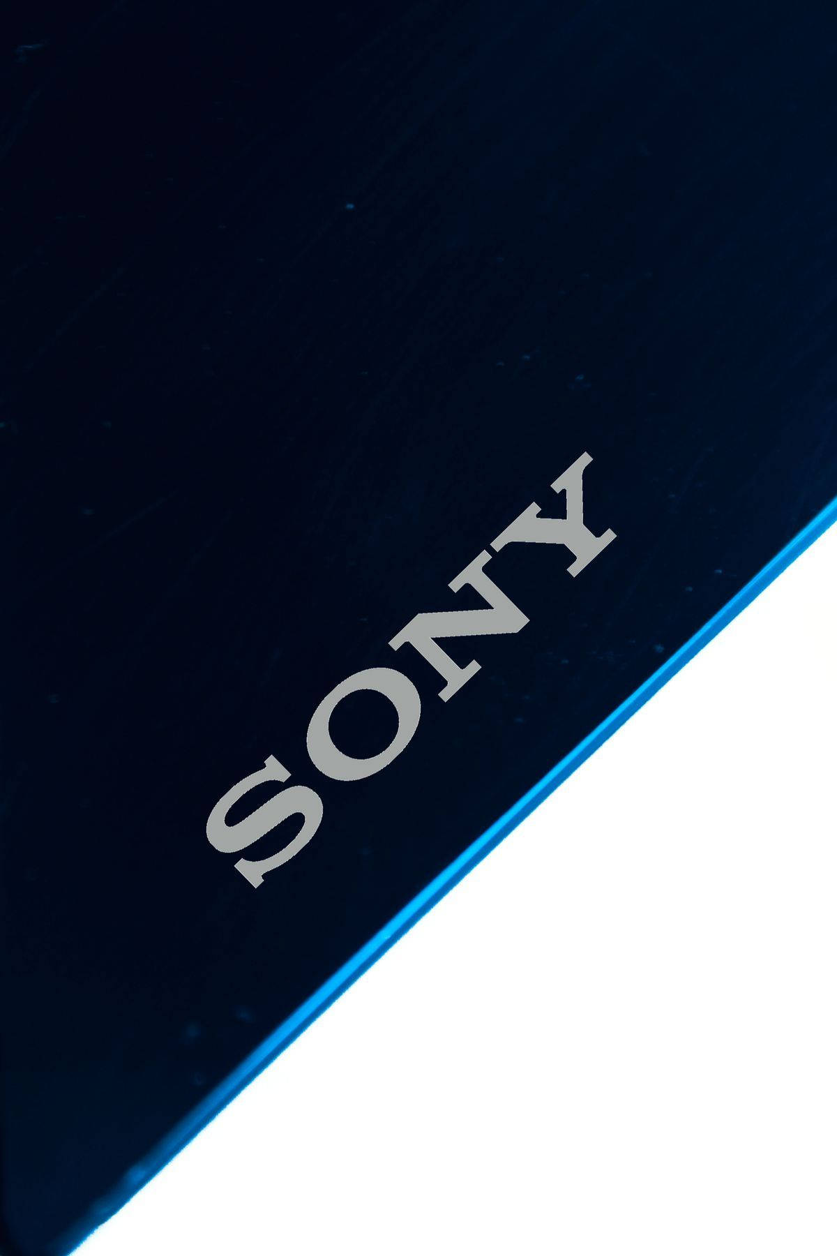 索尼黑白設計 壁紙 — 特寫一個時尚的深藍色Sony設備，帶有銀色標誌和發光藍色邊緣，背景為白色。