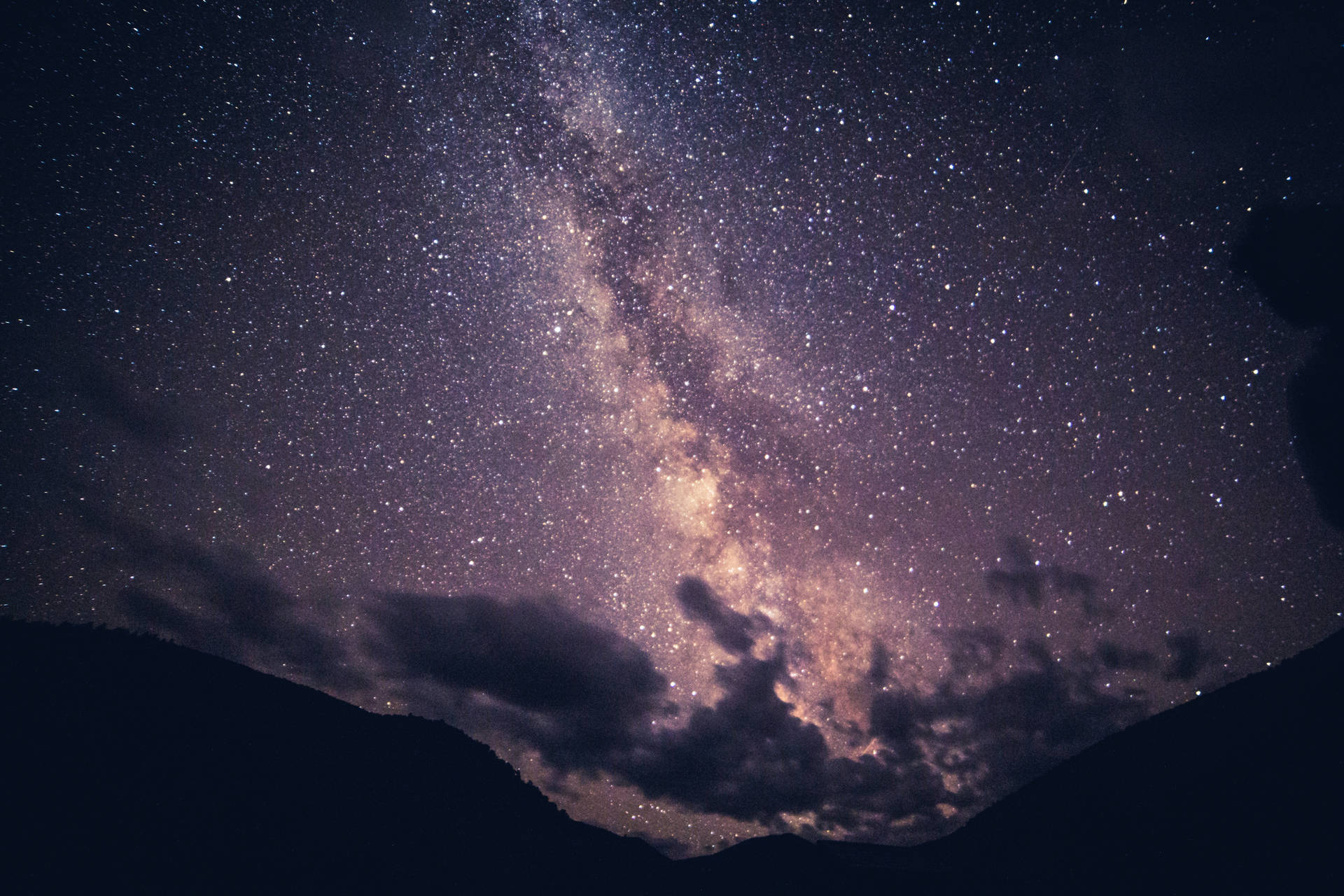 銀河系在繁星點點的夜空下，於山頂上方閃耀。