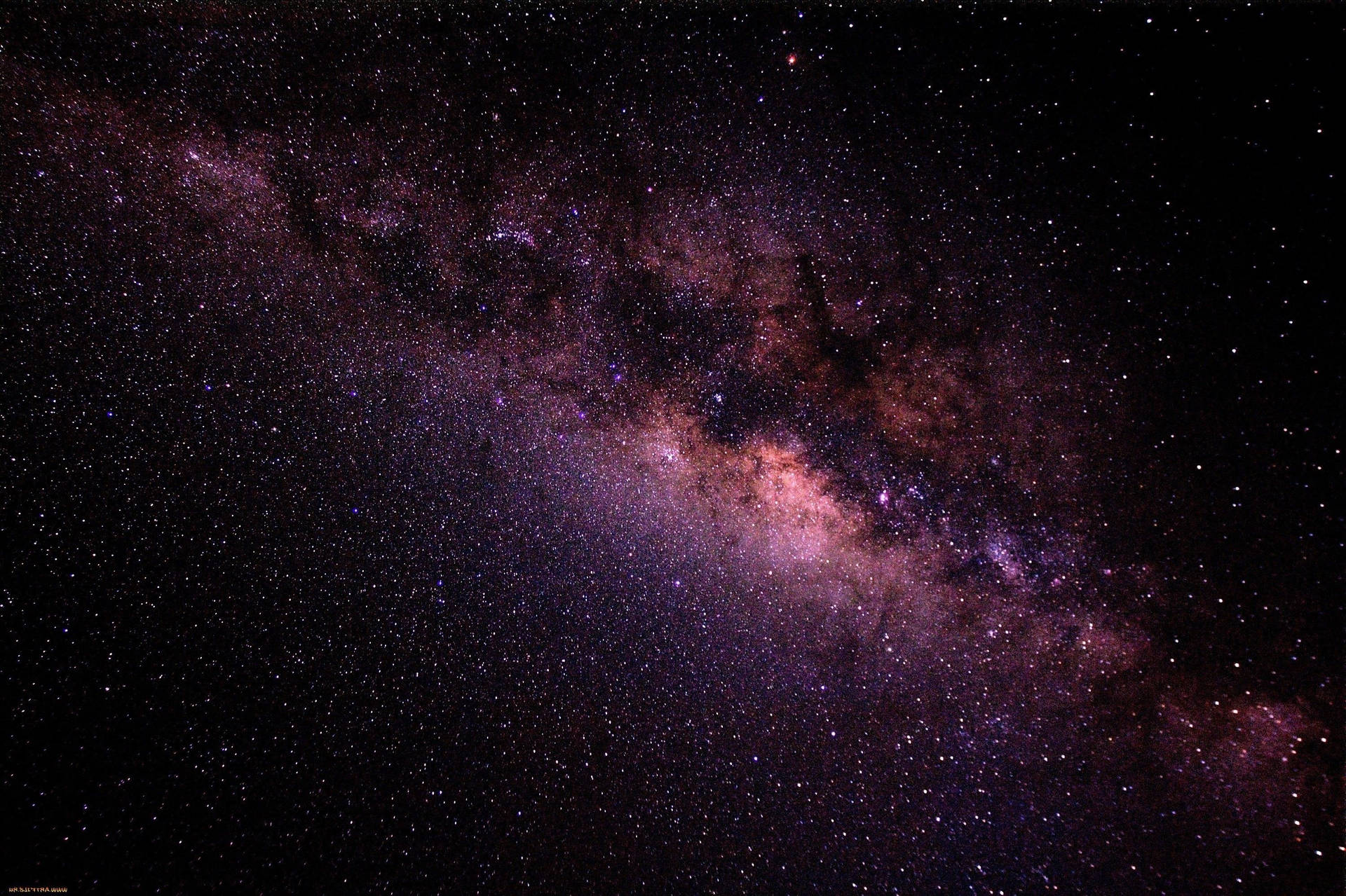 銀河系在夜空中閃耀著紫色和粉紅色的星雲。