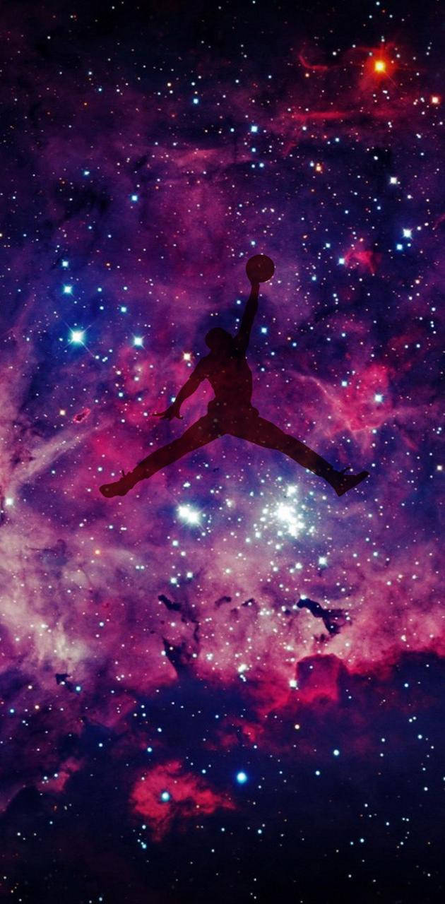籃球運動員剪影跳過色彩繽紛的星空星系。