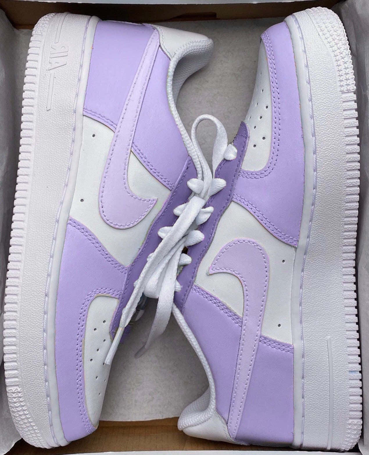 打開的盒子中的薰衣草紫和白色Nike Air Force 1運動鞋。