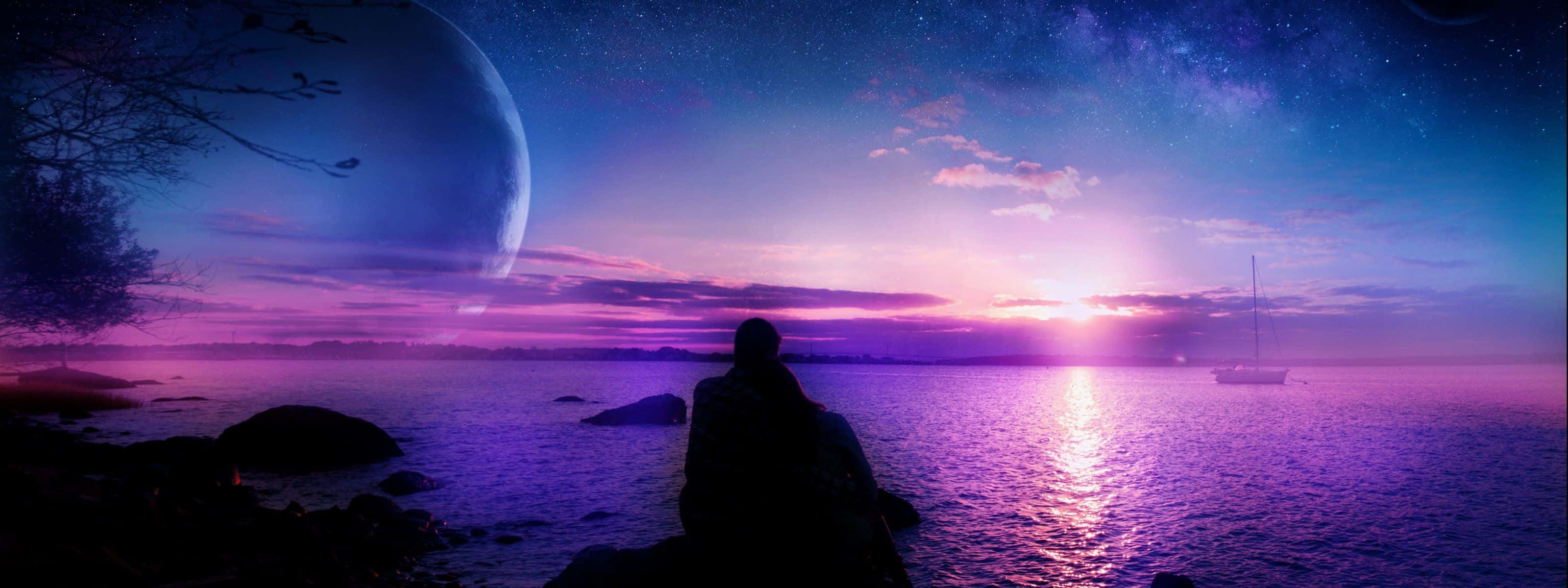 紫色夜空高清雙螢幕壁紙 壁紙 — 一個孤獨的身影坐在岩石海岸上，暮色中，一輪巨大的月亮在繁星點點的紫色天空和發光的水面上升起。