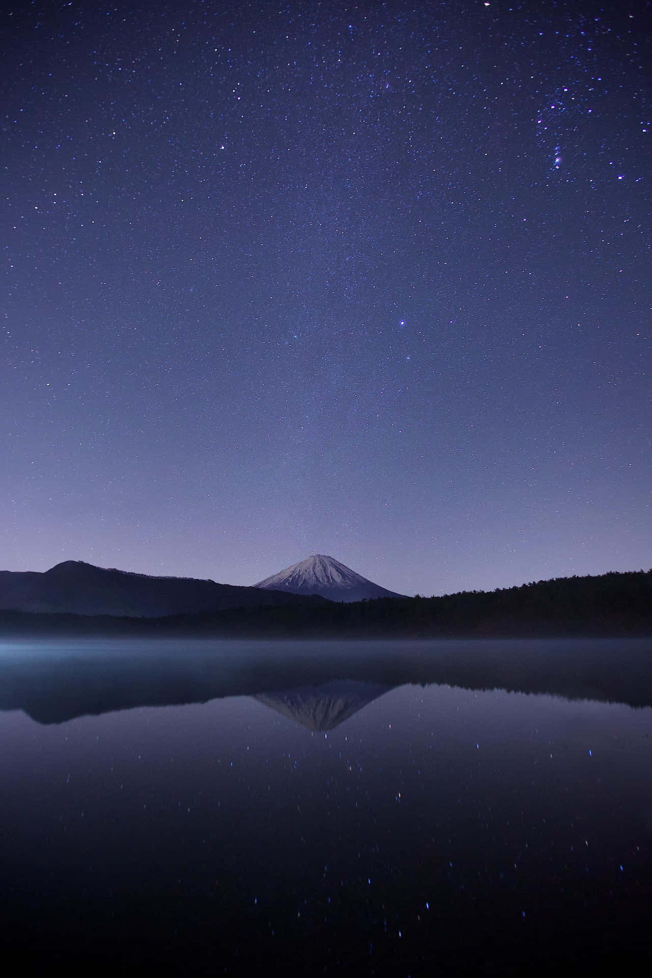 富士山在星夜下倒映在湖中。